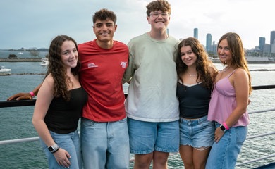 שלושה הורים מחייכים באירוע קהילתי