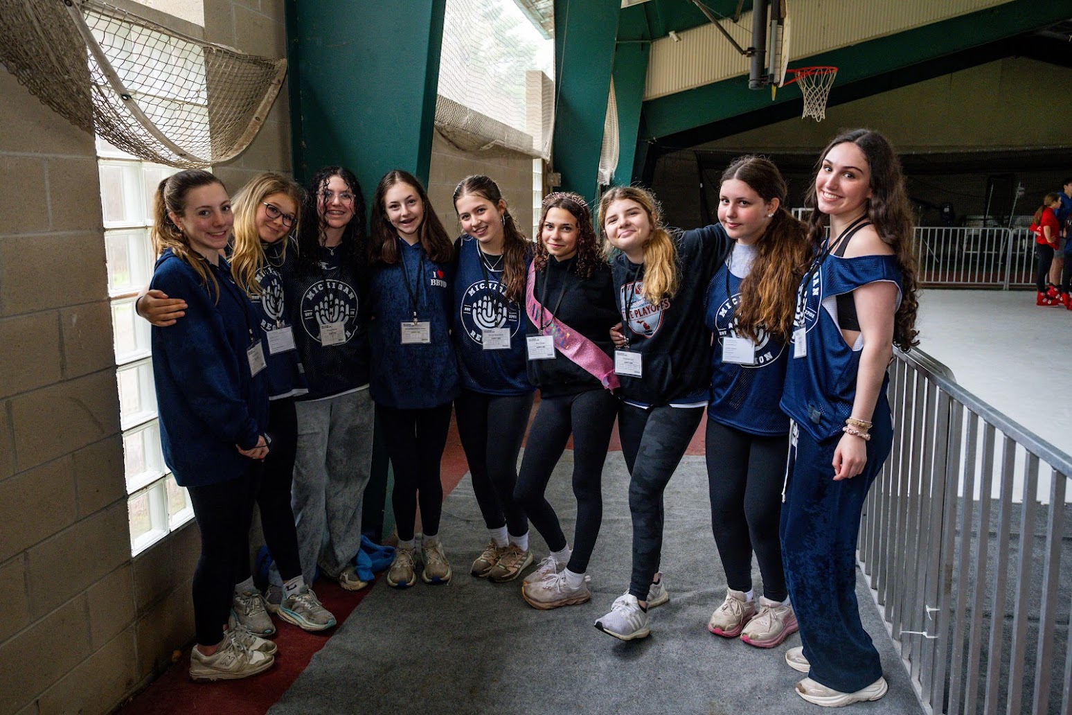 קהל מגוון של אנשים החוגגים בהופעה, מרימים ידיים ומריעים.